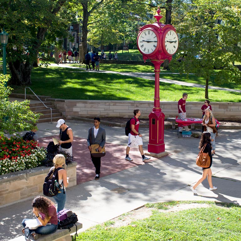 Students walk past a red clock on the IU Bloomington campus.